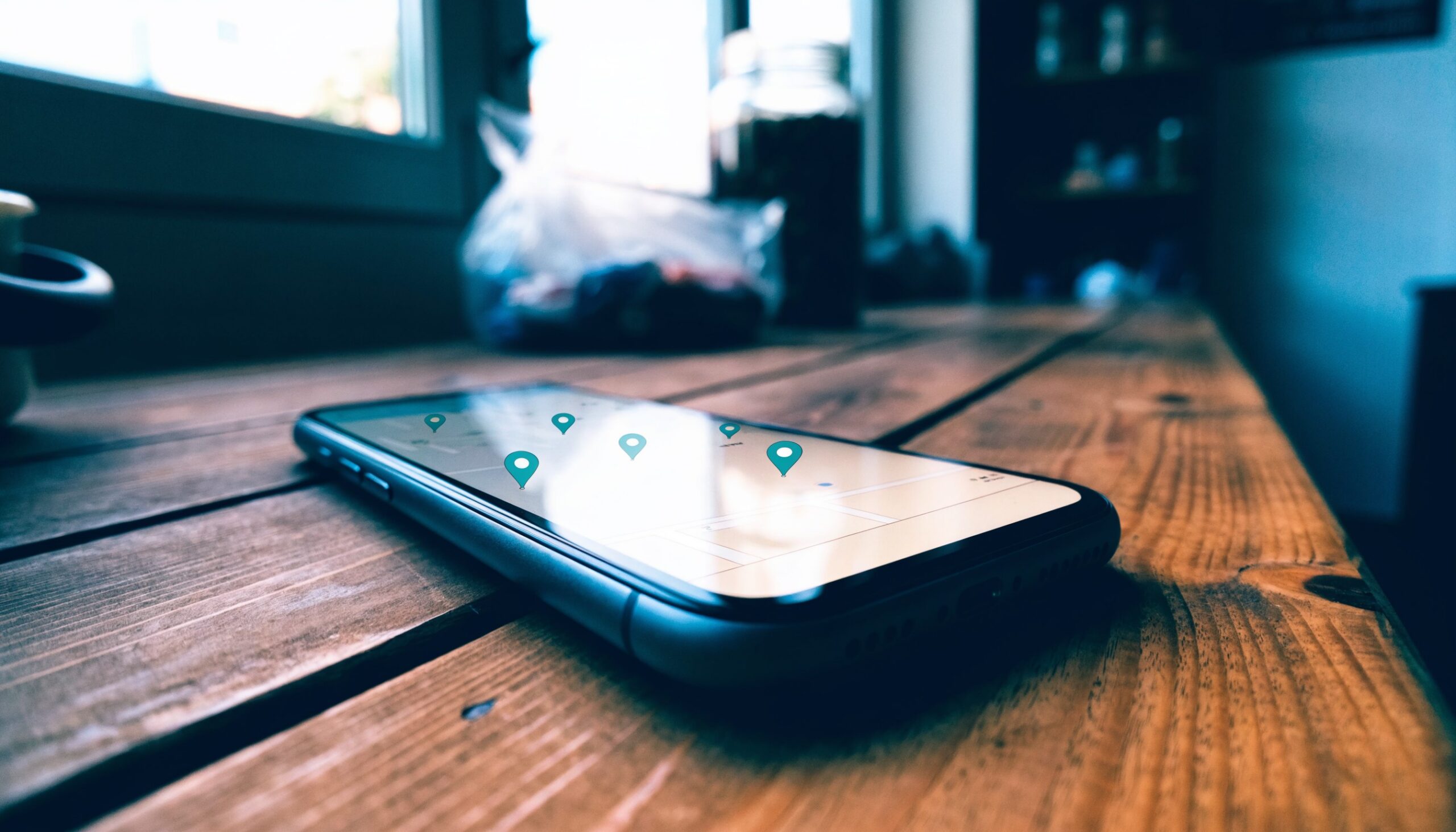 Smartphone auf einem Tresen zeigt eine Karte mit lokalen Standort-Pins – Google-Unternehmensprofil